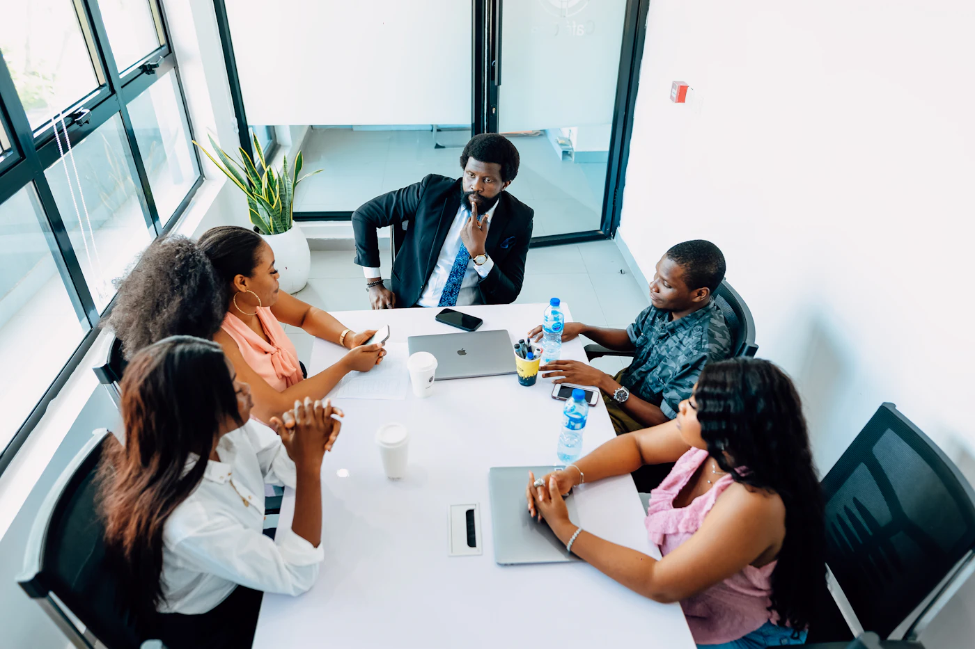 A team meeting around a white table in a sunny office