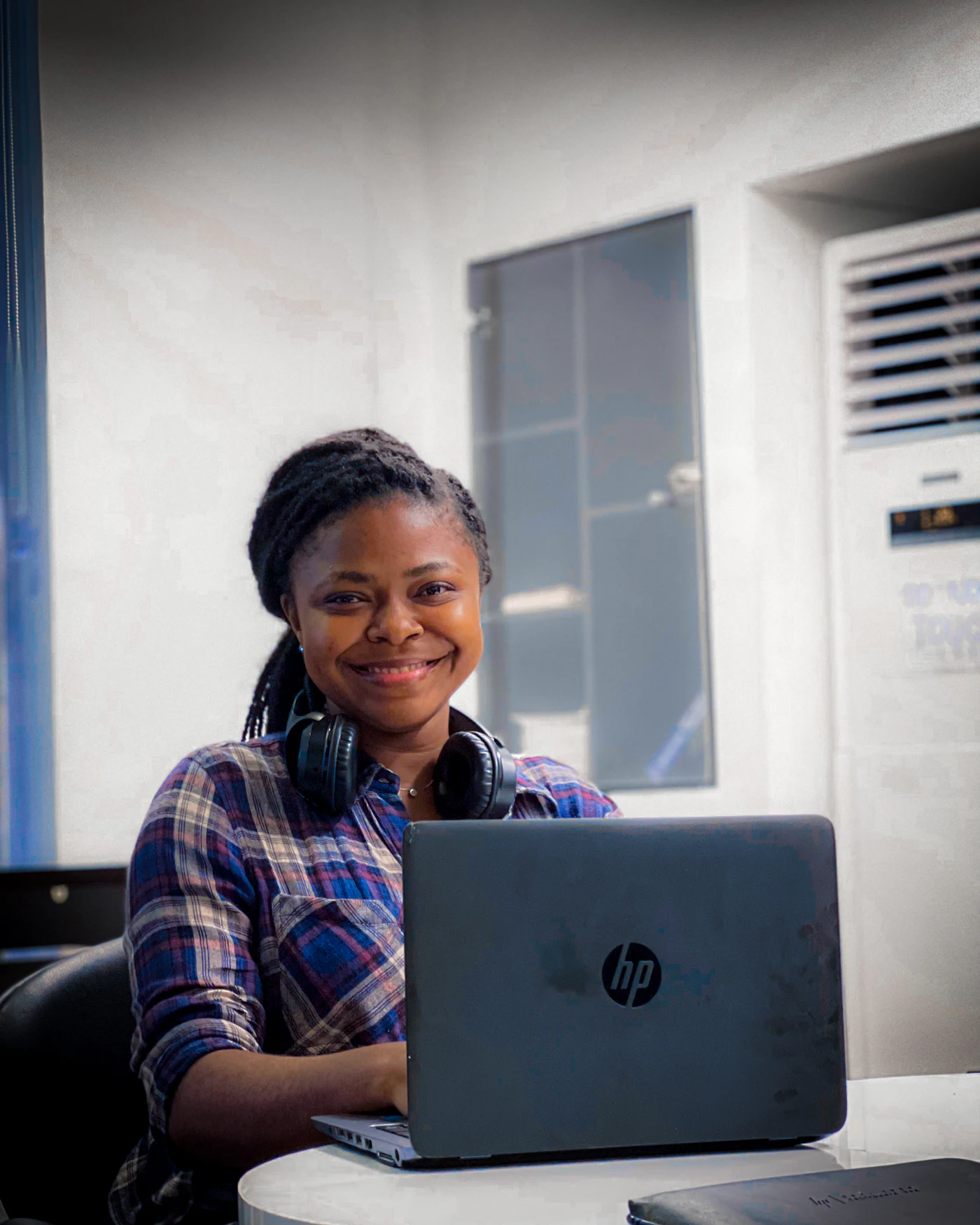 A smiling support team member with headphones at her laptop